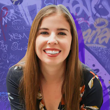 Woman smiling in front of a purple background